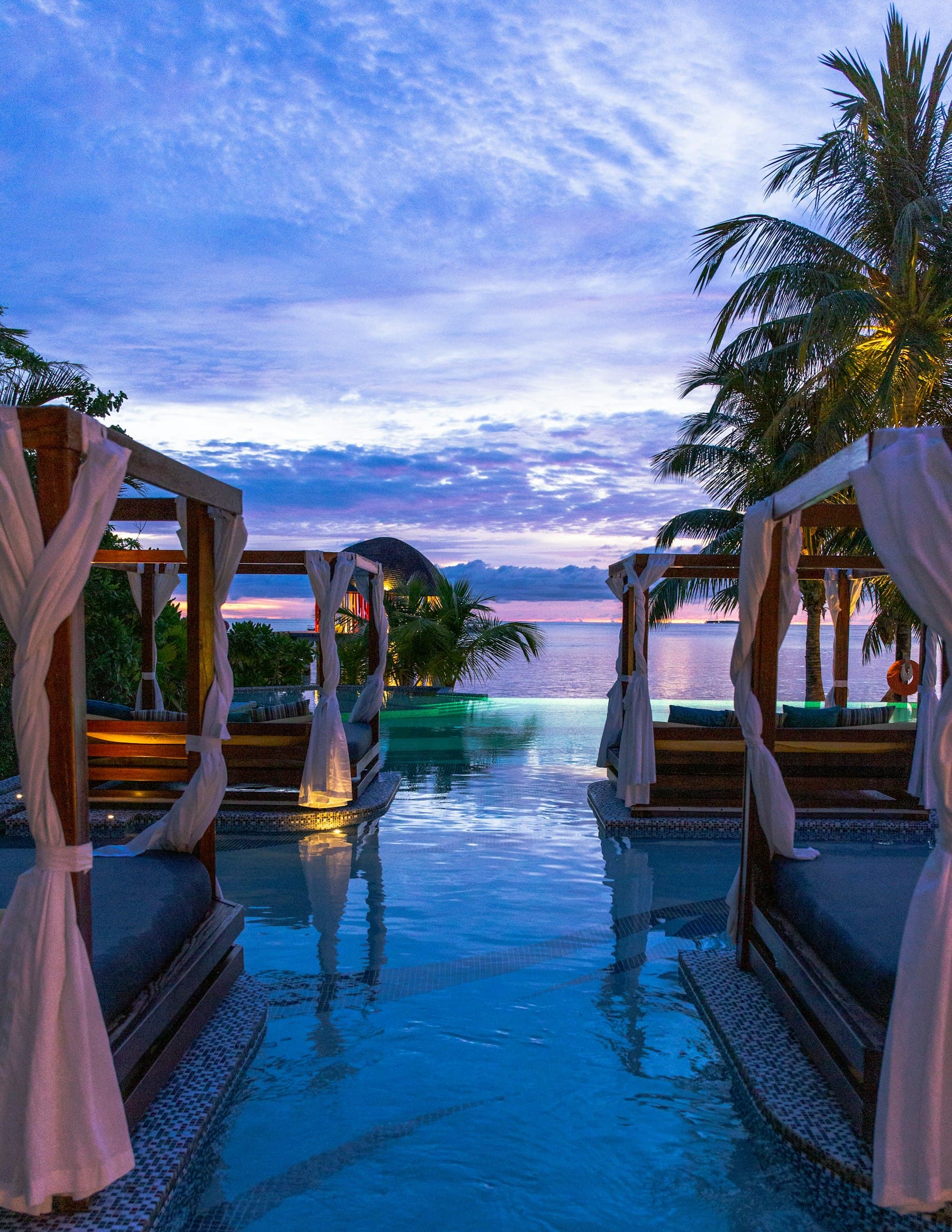 Infinity pool with cabanas at twilight